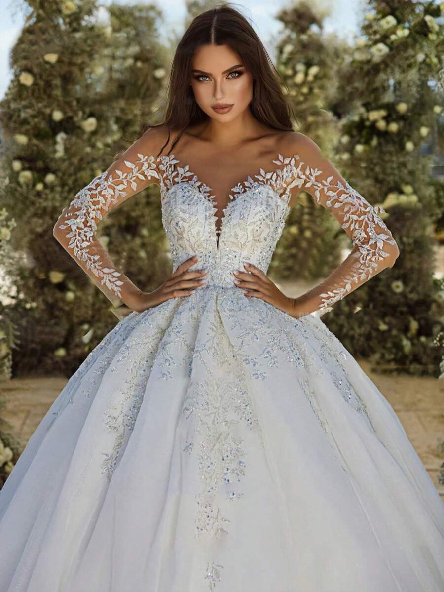 Romantic Off-Shoulder Long Sleeve Lace Appliqué Ball Gown Wedding Dress With Deep V-Neck And Open Back – Premium Soft Tulle With Hand-Applied 3D Floral Lace Appliqués, Off-Shoulder Neckline With Illusion Long Sleeves, Fitted Bodice With Deep V-Neck And Open Back, Full A-Line Ball Gown Skirt With Floor-Length Train, Available In Ivory – Perfect For Spring/Summer Outdoor Weddings, Garden Ceremonies, And Vintage Themed Events, Lightweight And Flowing Design, Ideal For Warm Weather, International Export Quality, Suitable For Global Bridal Market - Blanco - Ver 1