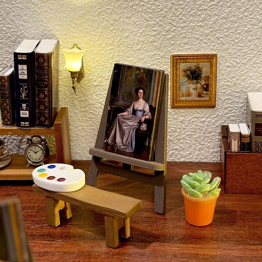 一幅精美的1:12比例中世纪少女油画微缩模型,配有画架、画布、调色板和微缩盆栽。精致的细节使其非常适合装饰娃娃屋或作为微缩摄影道具。 - 均碼 - 查看 1