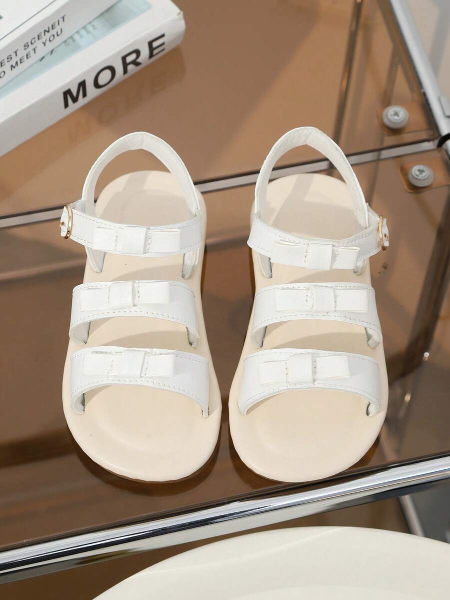 1 paire de sandales de plage blanches pour filles, couleur unie, patchwork en PU souple et tissu, décoration nœud, fermeture à crochet et boucle sur une seule sangle au talon, sandales plates style princesse mignon et à la mode, convient pour le quotidien décontracté, les vacances à la plage, le port en extérieur, printemps/été nouveau 2026 - Blanc - Voir 1