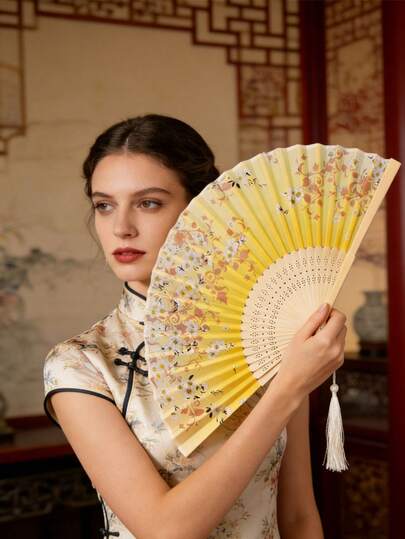 这款复古竹制折扇饰有优雅的丝绸花边流苏，并采用樱花和莲花图案设计。它是一款便携式传统东方扇，适用于婚礼、派对、角色扮演、舞蹈、夏季降温、家居装饰和馈赠亲友。这款轻巧的手持扇适合日常使用和节日庆典。它融合了古典美学与现代实用性，彰显了东方高雅的魅力。