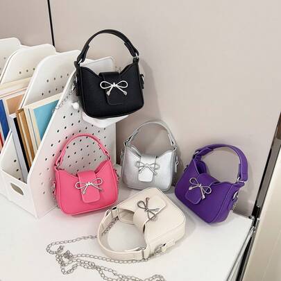 1 chiếc túi đeo chéo thời trang cho bé gái, chất liệu PU, trang trí nơ, có ngăn đựng son môi mini, phù hợp cho mọi mùa.