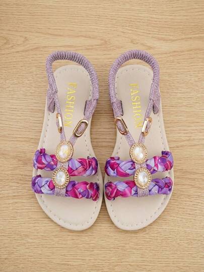 外观出众。甜美编织轻便凉鞋，适合3-12岁儿童。渐变紫粉色缎面编织带搭配编织设计。露趾平底鞋型，搭配亮面弹力后跟系带。宝石、水晶装饰，金色滚边。温柔精致的复古风格。适合日常出行、甜蜜约会和短途旅行。是春夏外穿的完美之选！