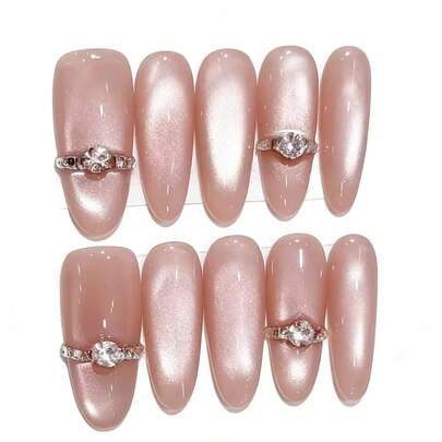 Bộ 10 móng này có tên là Ring Light Pink Sequence. Bộ móng này thể hiện kết cấu lấp lánh mắt mèo liền mạch, với chi tiết nhẫn kim cương 3D nổi bật trên nền hồng nhạt như một chiếc nhẫn bắt sáng trên bề mặt lụa hồng. Lớp phủ bóng tạo thêm nét sang trọng tinh tế, mang đến vẻ ngoài điềm tĩnh và tinh tế.