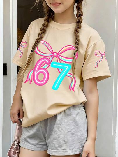 This Light Apricot Round Neck T-Shirt Is Designed For Girls, Printed With A Creative Blue Bow And The Number "67", Very Suitable For Young Girls To Wear. It Is Suitable For School, Shopping, Daily Wear And Vacation Occasions.