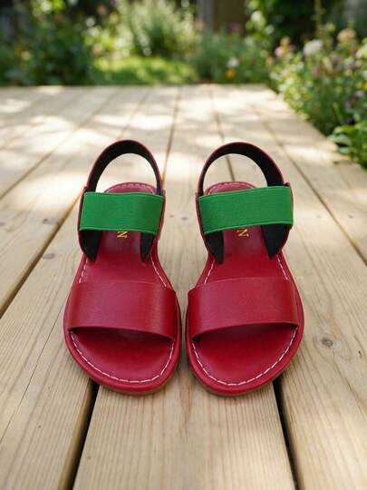 这款复古撞色弹力踝带凉鞋，适合3-12岁儿童，外观出众。鞋面采用红色仿皮材质，搭配高弹绿色松紧带和后系带。露趾平底设计，鞋底与鞋面同色，并饰有醒目的白色线条。大胆而充满活力的复古风格，适合日常上学、户外运动和短途旅行。是春夏外穿的理想之选！