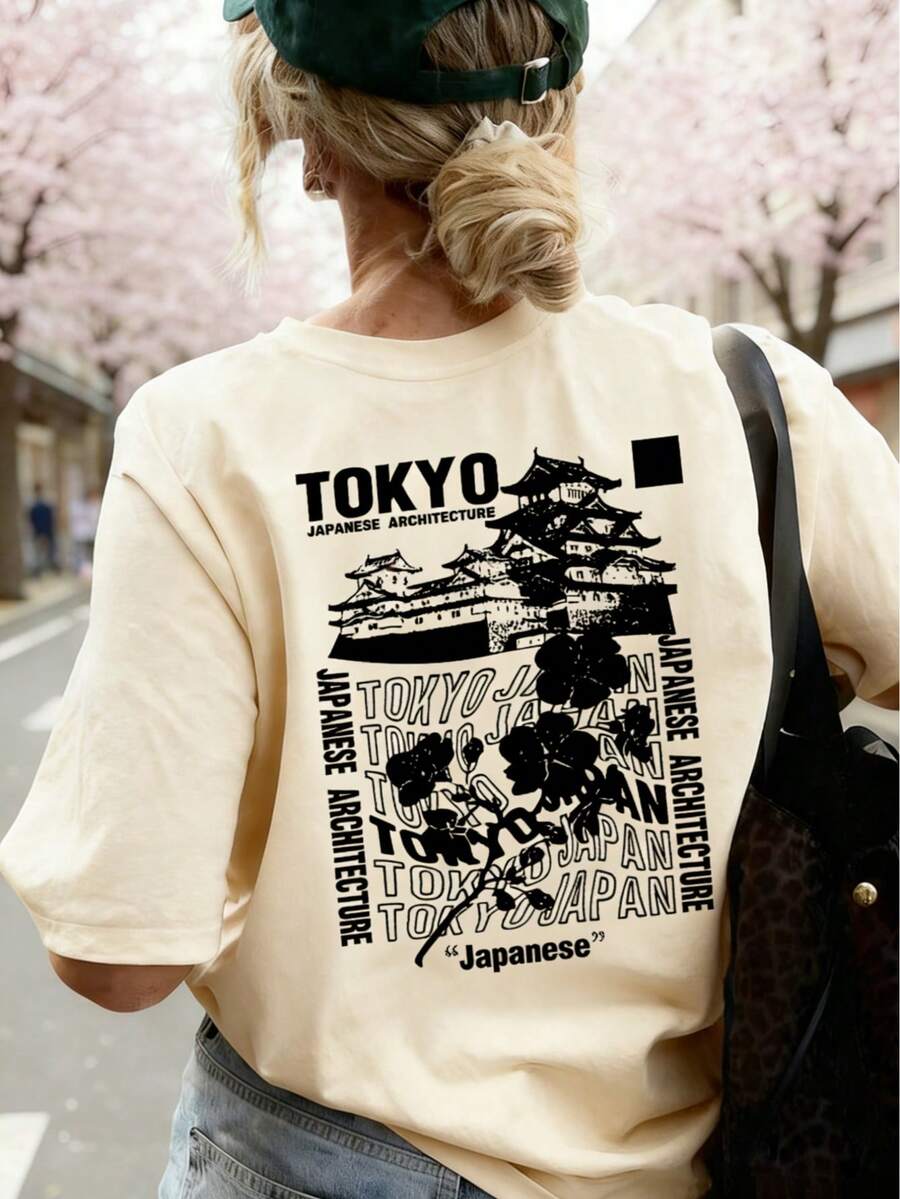 女士杏色短袖T恤，采用耐磨面料，背面印有东京古建筑和黑色花卉拼贴图案，展现日式极简街头风，适合城市漫步、艺术展览和旅行摄影。休闲夏季之选。