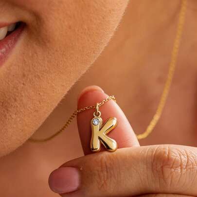 这款优雅的金色女士吊坠项链共有1件，配有26个镶嵌钻石的字母吊坠。时尚高贵的设计简约而不失精致，百搭实用，适合日常佩戴或作为礼物。