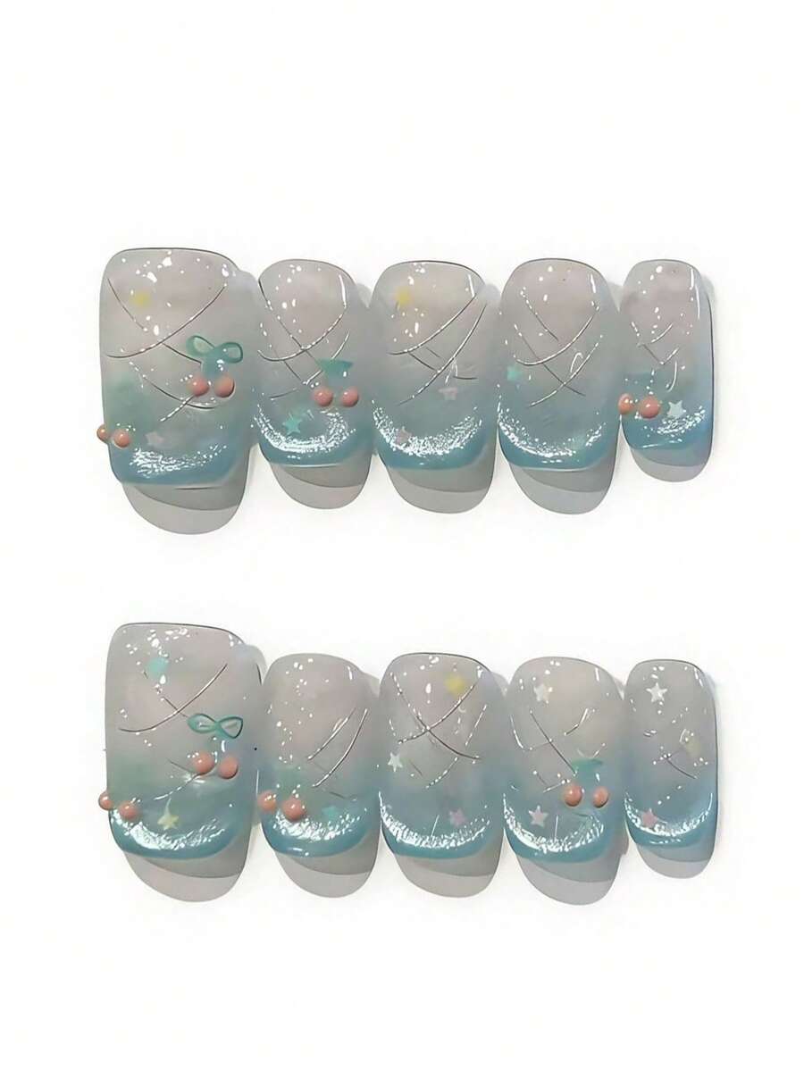 Bộ 10 móng giả mang tên Teal Mist Star Bow. Bộ móng này có lớp nền màu trắng sữa trong suốt với hiệu ứng chuyển màu xanh ngọc nhẹ nhàng, kết hợp với các đường chỉ bạc, điểm xuyết những hạt cườm nhỏ màu hồng, chi tiết ngôi sao óng ánh và một chiếc nơ màu xanh ngọc tinh tế. Lớp sơn bóng loáng bắt sáng như những giọt sương mai, tạo nên vẻ đẹp mộng mơ, huyền ảo, vừa dịu dàng vừa quyến rũ. - Màu xanh bạc hà - Xem 1