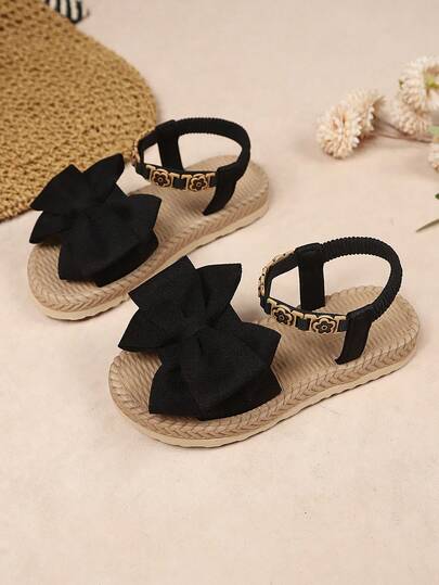 1 đôi dép xăng đan đế bằng màu đen cho bé gái sơ sinh/trẻ nhỏ, chất liệu vải mềm mại, trang trí nơ lớn, mũi tròn, hở mũi, đế co giãn thoải mái, gót chống trượt, quai chun họa tiết hoa nhỏ, kiểu dáng xỏ chân tiện lợi, phong cách bohemian thời trang, dép công chúa dễ thương, thích hợp cho đi chơi hàng ngày, đi biển, đi học, lễ hội, mẫu mới xuân/hè.