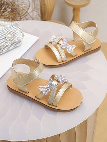 Một đôi sandal trẻ em màu sâm panh với nơ 3D và đá đính lấp lánh rất đáng yêu và ngọt ngào, phù hợp để sử dụng hàng ngày. Thích hợp cho các bữa tiệc, buổi biểu diễn và nhiều dịp khác.