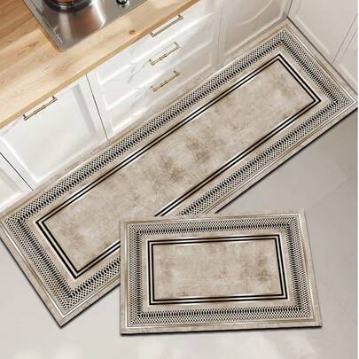 1 tấm thảm bếp bằng gel silica, kiểu dáng tối giản sang trọng với nền màu xám bạc, viền đen vàng tinh tế và khung hình học rỗng, phù hợp với nội thất tối giản hiện đại hoặc nhà sang trọng. Thảm bếp thời trang cao cấp, êm ái chống mỏi chân, chất liệu vải bề mặt, lớp giữa là mút xốp thấm hút, lớp dưới là cao su, dễ dàng vệ sinh, độ dày khoảng 3.5mm.