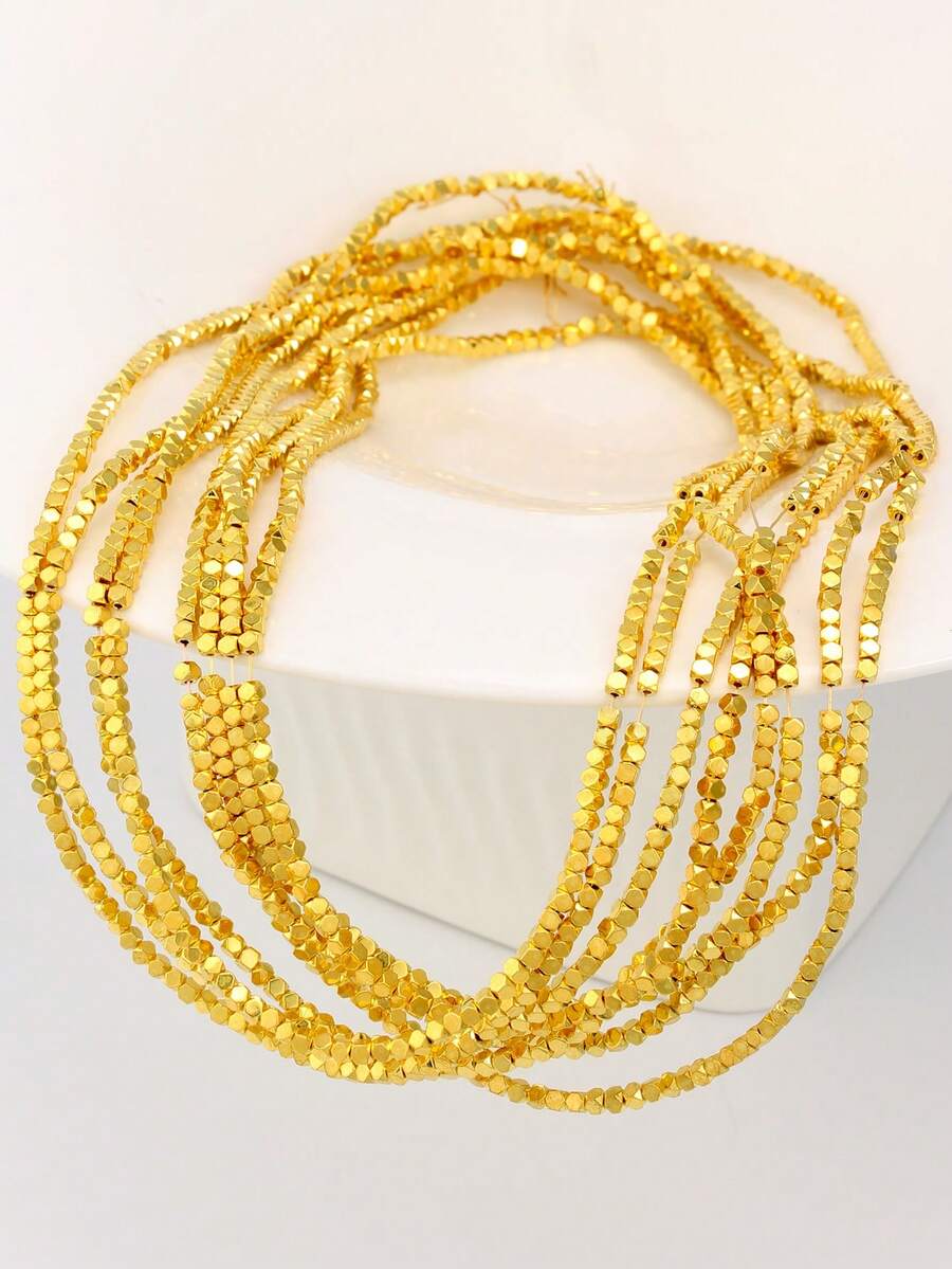 Một món phụ kiện tự làm như vòng tay, vòng cổ hoặc bông tai được làm từ hạt đá hematit hình vuông 2mm, ngăn cách bởi các hạt đệm, tỏa sáng nhờ chất liệu thủ công.