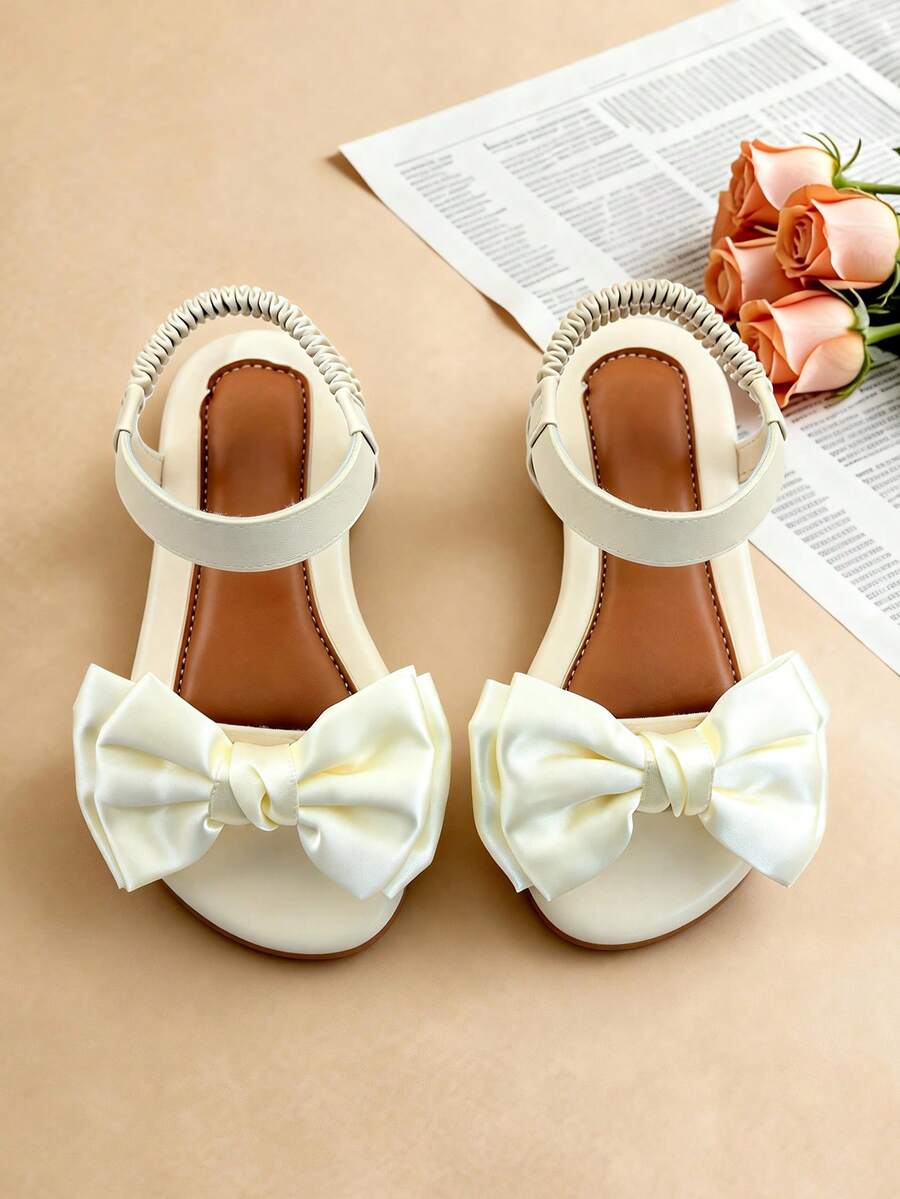 1 đôi dép xăng đan trẻ em màu trắng thời trang, dép xăng đan đế bằng mùa hè cho bé gái, thiết kế quai sau co giãn với nơ lớn bằng satin, đế mềm chống trượt bền chắc, thích hợp cho các buổi tiệc, họp mặt, đám cưới, kỳ nghỉ. - trắng - Xem 1
