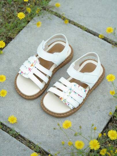 Dép xăng đan La Mã họa tiết hoa tươi tắn dành cho trẻ em 3-12 tuổi "Nhắm mắt để bước vào" - Chất liệu giả da màu trắng với viền hoa nhỏ nhiều màu sắc. Kiểu dáng hở mũi, đế bằng với nhiều quai ngang mắt cá chân phía sau và khóa dán. Đế chống trượt màu nâu với họa tiết vân nổi. Phong cách tươi tắn, mộc mạc, trẻ thơ. Thích hợp cho việc đi học hàng ngày, các hoạt động ngoài trời và những kỳ nghỉ ngắn. Hoàn hảo cho trang phục ngoài trời mùa xuân và mùa hè!