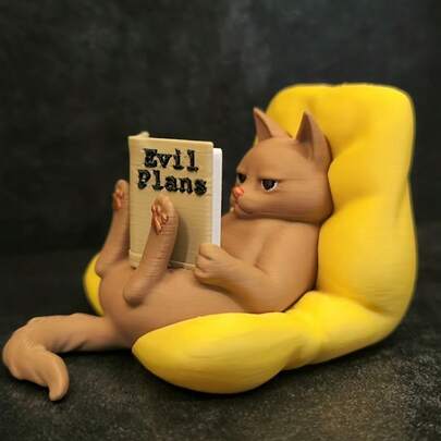 A Charming Little Statue Of A Cat, Completely Absorbed In Reading