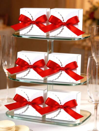 Hộp quà vuông bằng giấy màu trắng đơn giản, viền lượn sóng, trang trí nơ ruy băng satin đỏ, thiết kế gấp gọn tiện lợi cho việc cất giữ và vận chuyển, thích hợp làm quà tặng đám cưới, quà đính hôn, quà cho phù dâu, quà sinh nhật, quà tặng doanh nghiệp, quà tặng ngày lễ, đựng kẹo, trang sức, nến và các món quà nhỏ khác. Trang trí đa năng, thanh lịch và bền chắc.