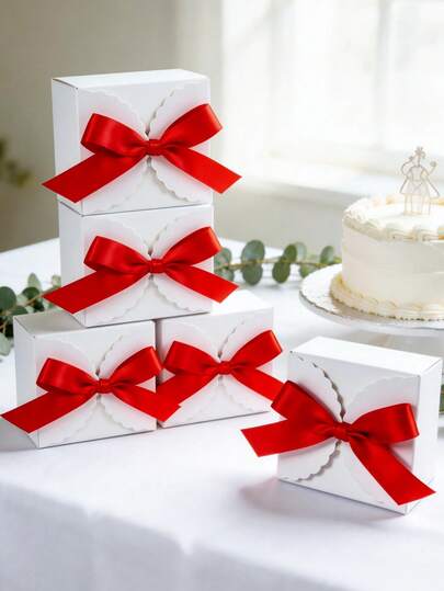 Hộp quà vuông bằng giấy màu trắng đơn giản, viền lượn sóng, trang trí nơ ruy băng satin đỏ, thiết kế gấp gọn tiện lợi cho việc cất giữ và vận chuyển, thích hợp làm quà tặng đám cưới, quà đính hôn, quà cho phù dâu, quà sinh nhật, quà tặng doanh nghiệp, quà tặng ngày lễ, đựng kẹo, trang sức, nến và các món quà nhỏ khác. Trang trí đa năng, thanh lịch và bền chắc.