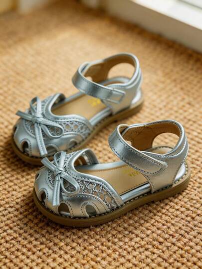 Sự lựa chọn sang trọng và thanh lịch - Sandal nơ ren kim loại cho bé gái từ 3-12 tuổi. Chất liệu da PU màu bạc ánh kim + nơ 3 chiều + vải lưới ren. Cấu trúc bảo vệ ngón chân dạng băng đô + quai cài kim loại. Đế chống trượt và chống mài mòn + lưới thoáng khí. Sang trọng và lấp lánh theo phong cách công chúa. Thích hợp cho đi học hàng ngày/dã ngoại/tiệc tùng/lễ hội. Sandal mùa xuân/hè!