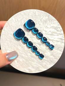 12片装（脚趾甲）为手工制作的深蓝色按压式脚趾甲，带有亮面猫眼图案和碎钻装饰。它们用途广泛，高端大气，适合女性和女孩在日常聚会和派对上佩戴。套装包含美甲贴纸、果冻胶和防滑贴。 - 寶藍色 - 查看 6