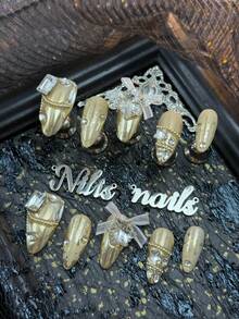 10-Piece Handmade Full-Coverage Fake Nail Set Featuring Almond Nails, Golden Nails, And Golden French Nails, Adorned With Golden Snowflake Patterns, 3D Large Square Diamonds & Large Snowflake Rhinestones, Paired With Small White Mesh Bows & Golden Small Beads Strung Into Chains & Transparent Small Rhinestones, And Other Nail Accessories. - Gold - View 3