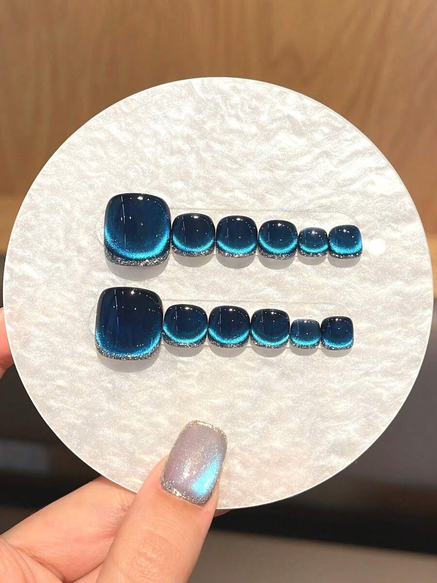 12片装（脚趾甲）为手工制作的深蓝色按压式脚趾甲，带有亮面猫眼图案和碎钻装饰。它们用途广泛，高端大气，适合女性和女孩在日常聚会和派对上佩戴。套装包含美甲贴纸、果冻胶和防滑贴。 - 寶藍色 - 查看 1