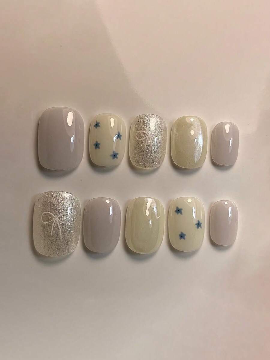 10片纯手工制作的按压式美甲贴片，短款椭圆形美甲贴片，柔和简约风格，浅紫色底色搭配闪亮对比的手绘蝴蝶结和花朵图案，可爱俏皮，适合女性和女孩，春夏秋冬节日派对及日常生活佩戴。 - 淡紫色 - 查看 1