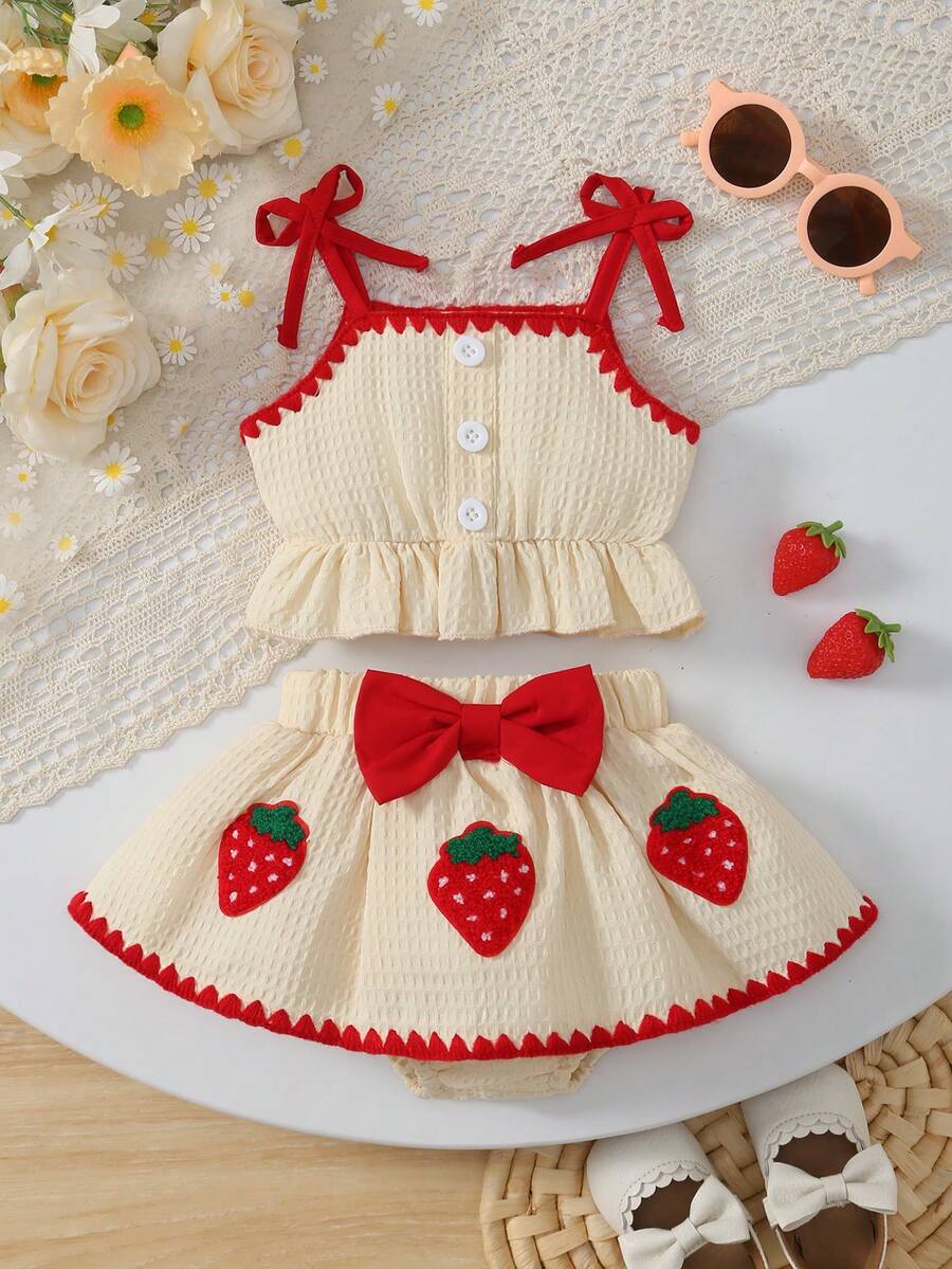 Bộ 2 món mùa hè ngọt ngào, kiểu retro gồm áo hai dây viền bèo nhún và chân váy ngắn thêu hình dâu tây, trang phục thường ngày.