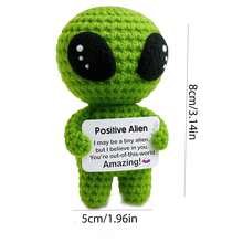 1个圆形绿色钩针外星人摆件，有着大大的黑色眼睛，举着一块写有鼓励话语的牌子：“我可能有点外星人，但我相信你——你在宇宙中很棒！”可爱又治愈的设计和文字能瞬间驱散低落的情绪和焦虑。 - 彩色 - 查看 2
