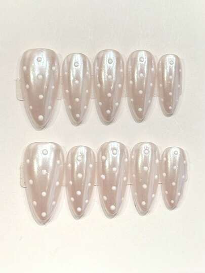 10片纯手工制作的中号杏仁形美甲贴片，以珍珠白为底色，搭配白色波点装饰，既优雅又复古。温柔优雅的可爱美甲，适合女士和女孩在春夏秋冬的各种节日派对和日常生活中使用。
