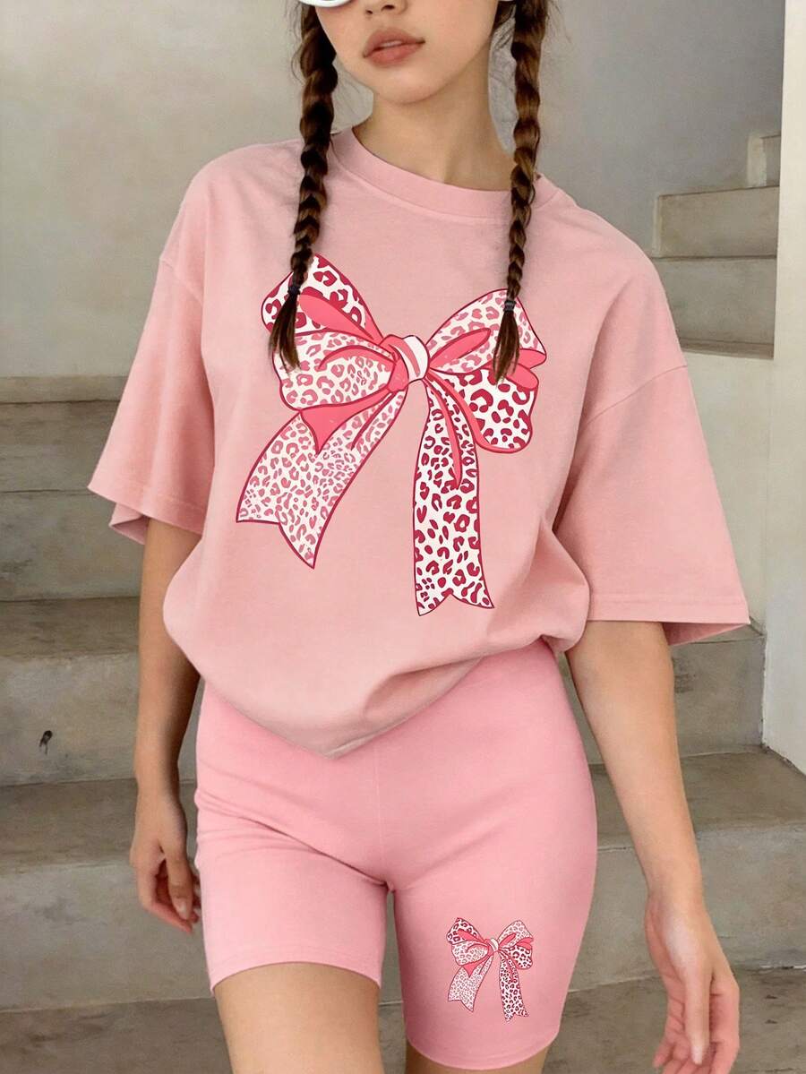 這套休閒套裝專為大童設計,包含一件粉紅色圓領T恤,印有創意蝴蝶結圖案,並搭配同款短褲。這也是送給朋友和家人的絕佳禮物。 - 粉色 - 查看 1