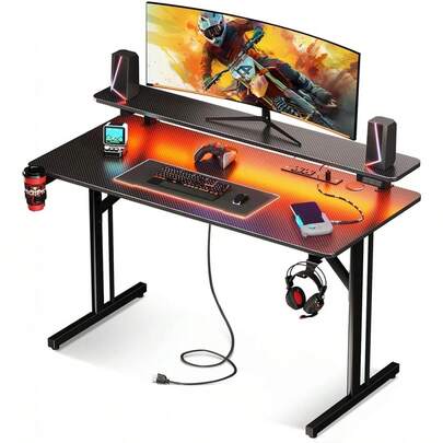 Escritorio Gamer RGB 1M con Luces LED, Soporte para Monitor, Enchufes Integrados, Gancho para Audífonos, Superficie de Fibra de Carbono Impermeable, Mesa para PC Gaming Negra