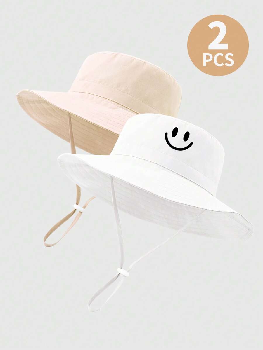 2 piezas Sombrero de sol para niños de unicolor con estampado de dinosaurio y correa para la barbilla, sombrero de cubo de protección solar de verano para la playa - Cara sonriente beige y blanca - Ver 1