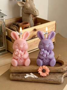 1个手工制作的大豆兔子手捧鲜花香薰蜡烛，适合情人节、婚礼季、母亲节、复活节等节日作为礼物，也可作为家居装饰。可爱兔子造型蜡烛，手工制作。 - 彩色 - 查看 1