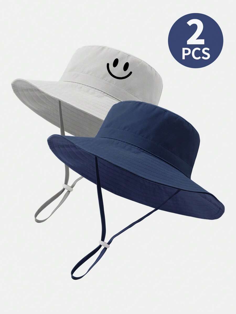 2 piezas Sombrero de sol para niños de unicolor con estampado de dinosaurio y correa para la barbilla, sombrero de cubo de protección solar de verano para la playa - Cara sonriente azul marino y gris - Ver 1