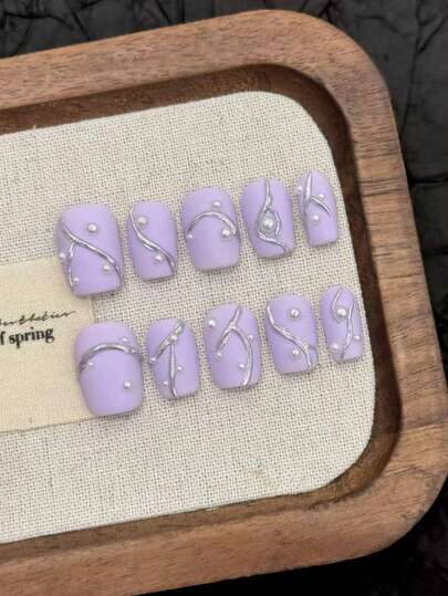 10 móng giả dán thủ công, màu tím oải hương mờ với họa tiết dây leo bạc và ngọc trai, mang đến cảm giác mùa xuân dịu dàng cho đầu ngón tay, nhẹ nhàng nhưng sang trọng. Hình dáng móng ngắn tròn rất thân thiện, đường viền dây leo bạc mang đến vẻ quyến rũ phương Đông, phù hợp cho cả đi làm và hẹn hò. Chất liệu mờ với chi tiết ngọc trai, tông màu tím nhẹ nhàng và tươi sáng, một kiểu móng tay phương Đông độc đáo với vẻ đẹp thần tiên.