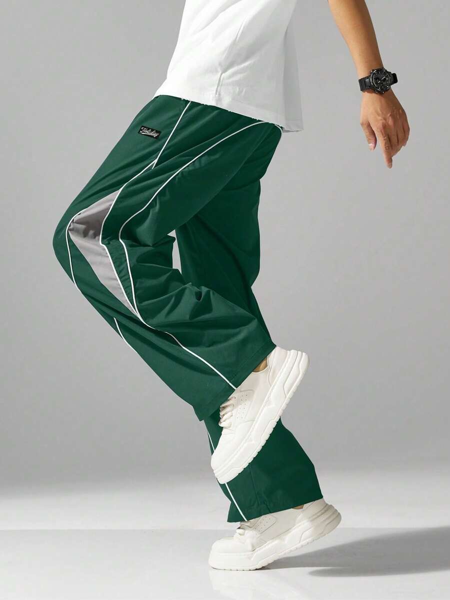 Quần jogger nam phong cách đường phố với sọc bên hông, túi và dây rút ở eo, quần thể thao phối màu tương phản, phù hợp cho thời gian rảnh rỗi và mặc dạo phố.