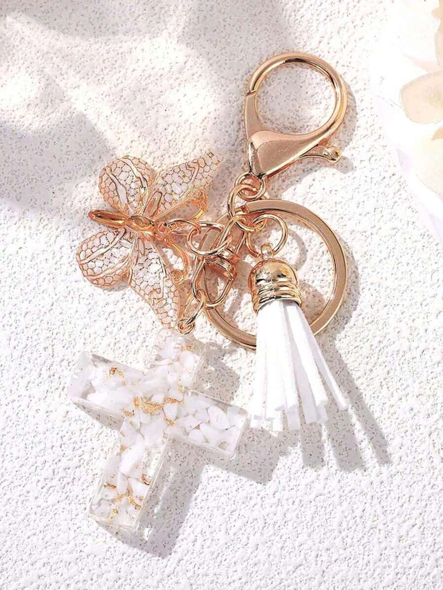 1个十字形树脂车钥匙挂件，镶嵌白色瓷石，饰以蝴蝶和流苏——男女皆宜的礼物，可作为汽车包包装饰，送给母亲、父亲、毕业生和老师。