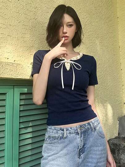 Áo thun nữ tay ngắn cổ tròn thắt nơ phía trước, vạt bèo nhún, kiểu 2 trong 1, dáng regular length, chất liệu co giãn cao.