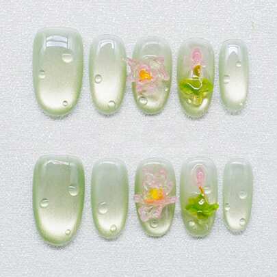 10片纯手工制作的中号椭圆形美甲贴片，以绿猫眼色为底，融合了立体莲花和水滴装饰，呈现出清澈活泼的外观。温柔优雅的可爱美甲，适合女士和女孩在春夏秋冬各种节日派对和日常生活中使用。