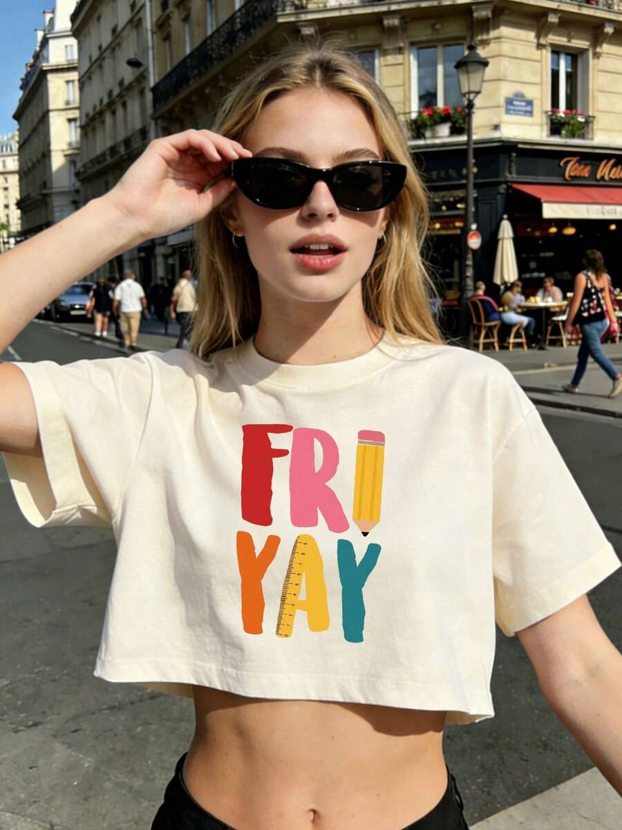 T-shirt estiva corta da donna in 100% cotone con una divertente stampa "FRIYAY": la lettera "I" è disegnata come una matita e la lettera "A" come un righello. Lo stile sportivo da college con un taglio corto e rilassato valorizza la figura e allunga la silhouette. Adatta per l'uso quotidiano, i viaggi, lo street style casual e i look da vacanza. - Albicocca - Visualizzare 1