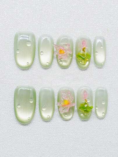 10片纯手工制作的中号椭圆形美甲贴片，以绿猫眼色为底，融合了立体莲花和水滴装饰，呈现出清澈活泼的外观。温柔优雅的可爱美甲，适合女士和女孩在春夏秋冬各种节日派对和日常生活中使用。