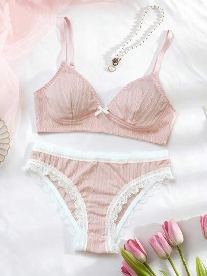 两件套莲花粉三角杯文胸套装，柔和哑光莲花粉色纹理面料，三角杯设计，轻盈舒适，白色蕾丝和蝴蝶结装饰，简约优雅，舒适时尚，适合日常穿着。