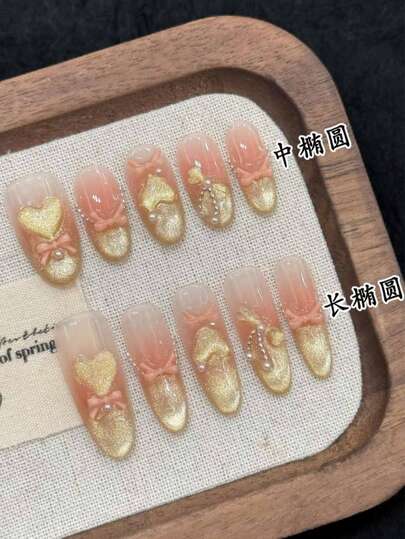 10片手工美甲贴纸，可拆卸按压式美甲，裸粉色渐变搭配金色闪粉，饰有3D蝴蝶结和爱心箔片，提供椭圆形和短椭圆形两种形状，柔美浪漫的洛丽塔风格，适合约会和通勤。
