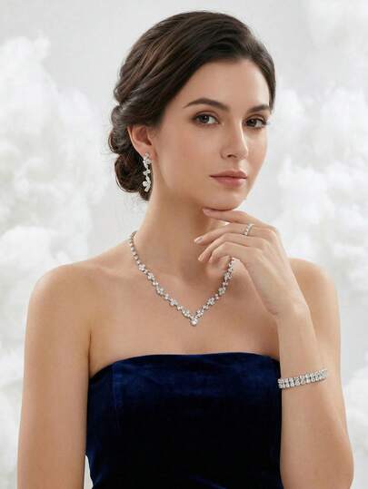 Bộ trang sức cưới đính đá lấp lánh 4 món sang trọng, gồm dây chuyền pha lê hình chữ V, bông tai dáng dài, vòng tay và nhẫn, thích hợp cho phụ nữ dự tiệc cưới, dạ hội.