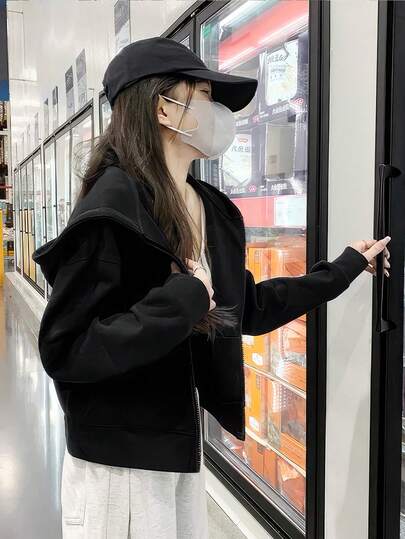 Áo nỉ trơn màu đen, kiểu dáng rộng rãi, đa năng, thoải mái.