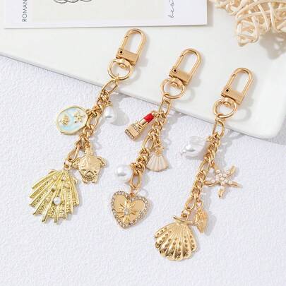 1 chiếc móc khóa sang trọng màu vàng kim thuộc dòng Ocean Series dành cho nữ, mặt dây chuyền hình trái tim, vỏ sò, sao biển và vỏ sò thanh lịch mùa hè, phụ kiện túi xách đa năng.