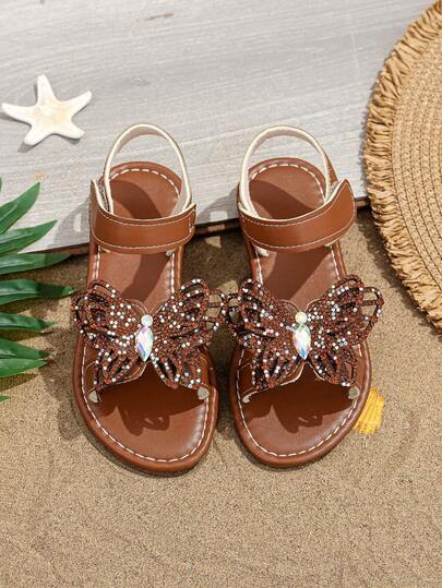 1 Đôi dép xăng đan thời trang cỡ lớn màu vàng kim dành cho bé gái, khóa cài đính đá lấp lánh nhiều màu sắc hình bướm rỗng, mũi tròn, hở mũi, đế mềm chống trơn trượt, kiểu dáng xỏ chân tiện lợi, dép xăng đan công chúa phong cách Bohemian dễ thương, phù hợp cho các dịp thường ngày, nghỉ lễ, đi học, dự tiệc, mùa xuân/hè. Hàng mới về
