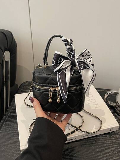 Mẫu túi xách mini mới mùa xuân 2026 dành cho nữ, túi đeo chéo hình thoi với dây xích và điểm nhấn là quả cầu vàng nhỏ.