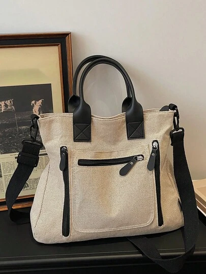 复古帆布撞色托特包，大容量手提包/单肩包，男女通用简约设计，耐用透气帆布材质，多拉链隔层方便实用收纳，前置口袋可放置个人物品，适合学生和日常通勤使用。