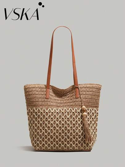 夏日度假风草编手提包 | 双色编织拼接设计，皮革肩带，流苏木珠装饰，大容量沙滩包/日常通勤包，轻松驾驭海滩、市集、咖啡馆等各种场景，成为您夏日造型的吸睛亮点。这款手提包设计容量充足，可轻松容纳遮阳伞、水瓶、沙滩巾、书籍，甚至笔记本电脑；是通勤、购物和短途旅行的理想之选。打造轻松又不失精致的造型。